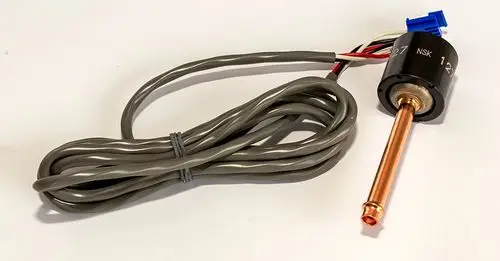 Niederdrucksensor mit grauem Kabel und einer Kupferleitung, schräg montiert, sorgt für die Funktionalität in Daikin Altherma-Systemen.